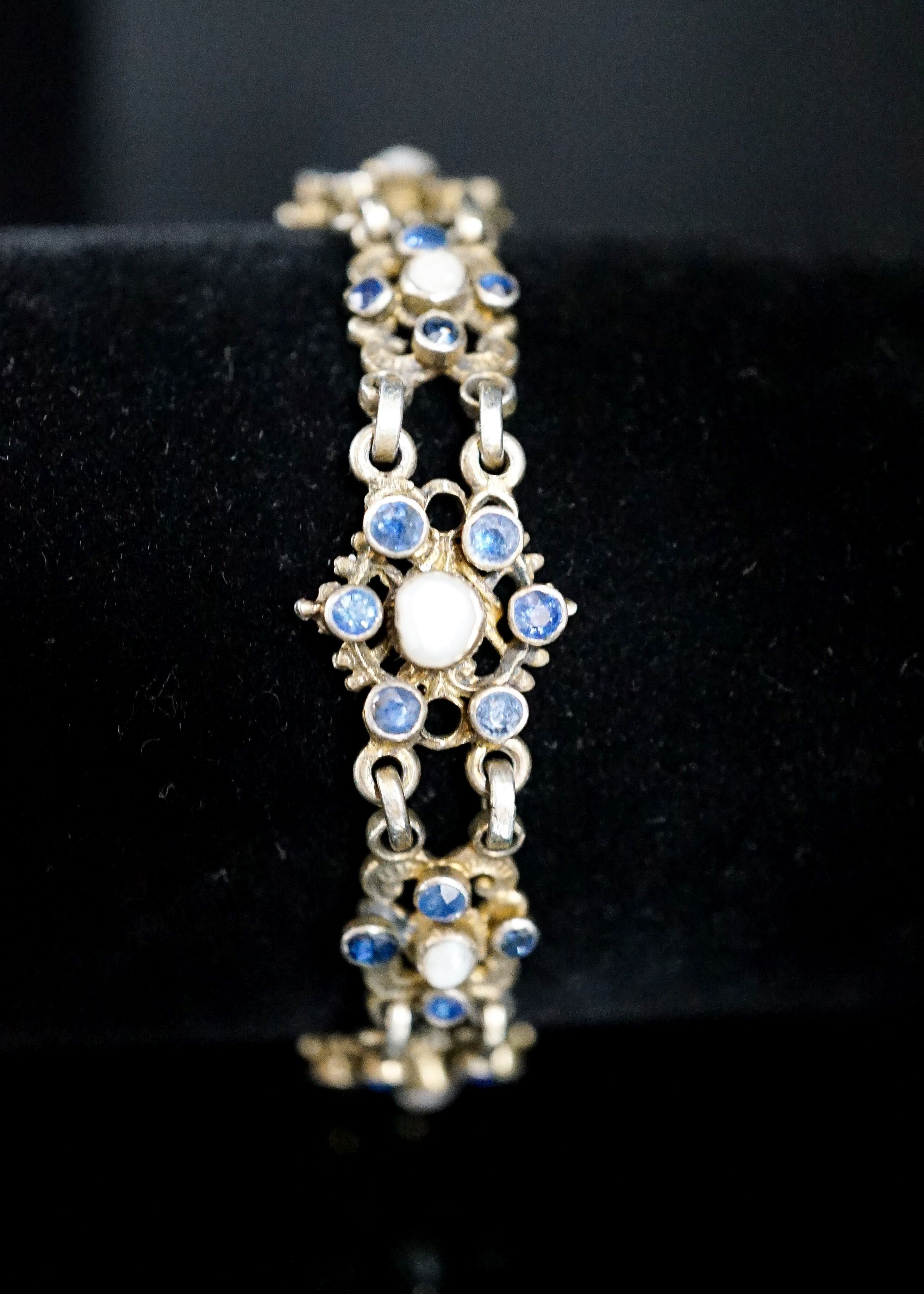 A continental gilt white metal, sapphire and split pearl flower head cluster set bracelet